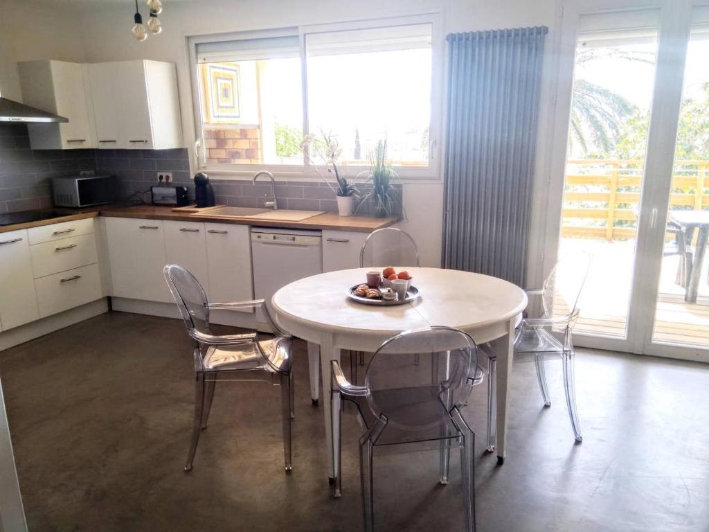 a kitchen with a table and chairs in a kitchen at Résidence tout confort Cabestany in Cabestany