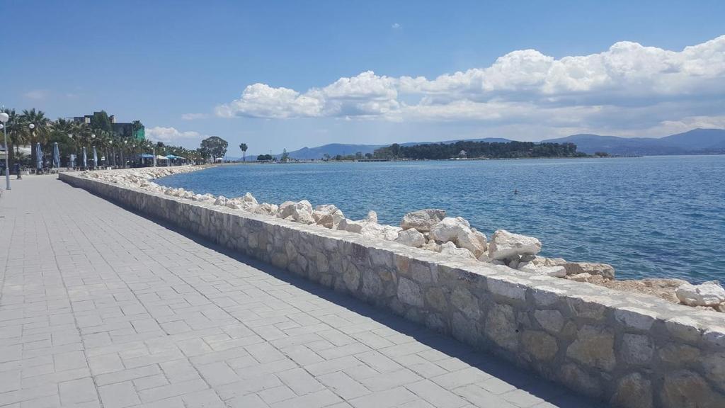 a stone wall next to a large body of water at Diamanto Rooms in Eretria