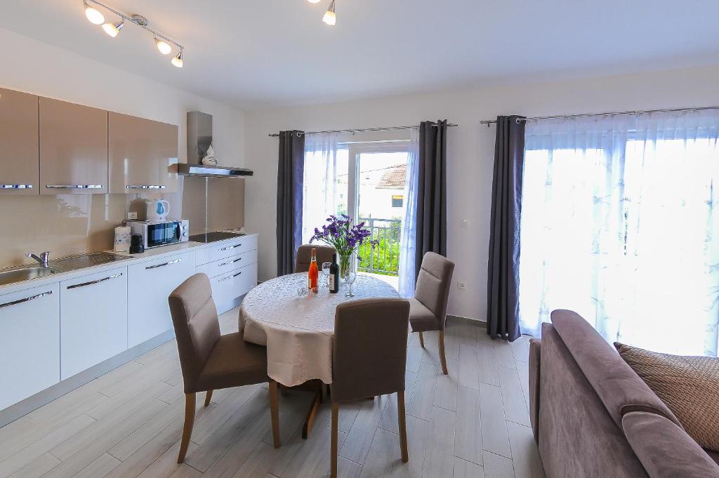 een keuken en eetkamer met een tafel en stoelen bij Apartment Petar in Kaštela