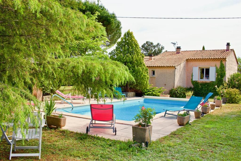 un patio con una piscina con sillas y una casa en Les murmures du Temps Villa 3 Chambres avec Piscine, en Carpentras