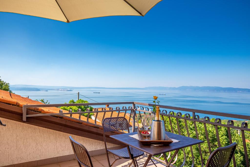 een tafel en stoelen op een balkon met uitzicht op de oceaan bij Korina in Kostrena