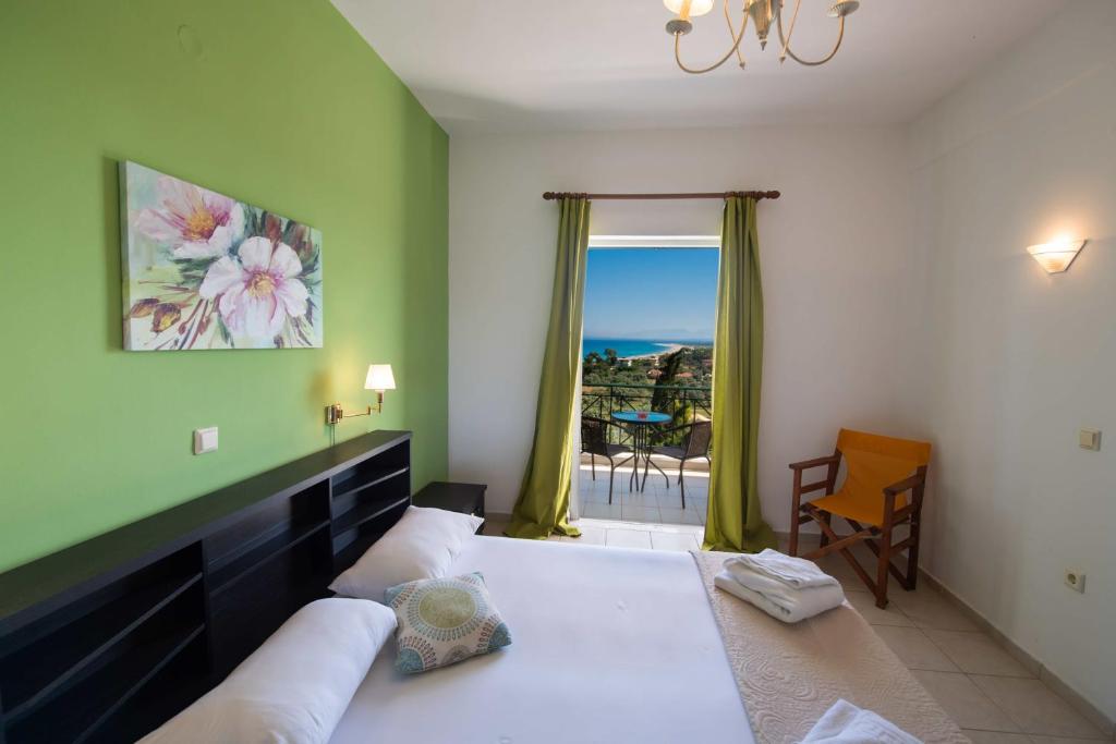 een slaapkamer met een bed en uitzicht op de oceaan bij Bella Casa Studios by Imagine Lefkada in Lefkada