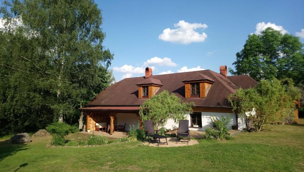dom z dachem gambrel na trawniku w obiekcie Forest Rustic Apartment Brdy w mieście Buková