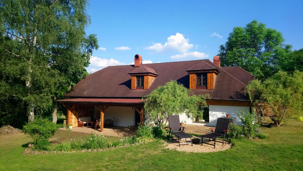 a large house with two chairs in a yard at Forest Rustic Apartment Brdy in Buková