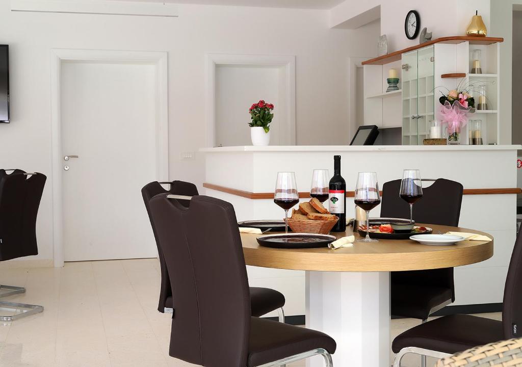 a dining room with a table and wine glasses at Cool Šilo Appartement Resort in Šilo