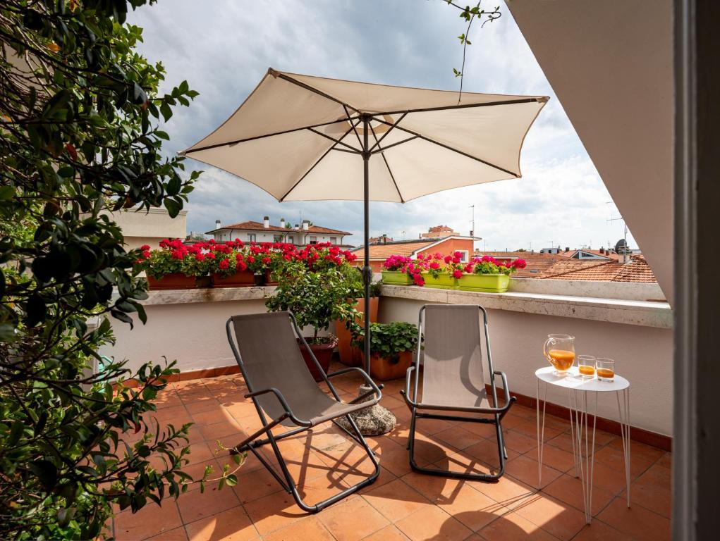 patio z 2 krzesłami i stołem z parasolem w obiekcie Casa di Anna w mieście Pesaro