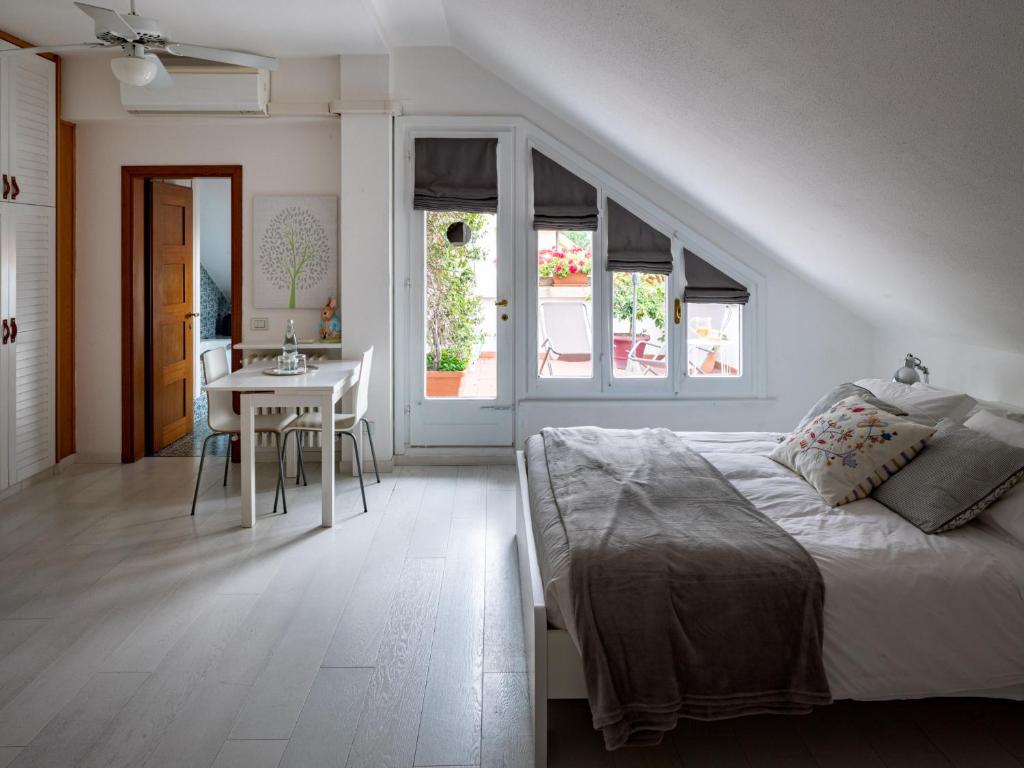 biała sypialnia z łóżkiem i stołem w obiekcie Casa di Anna w mieście Pesaro