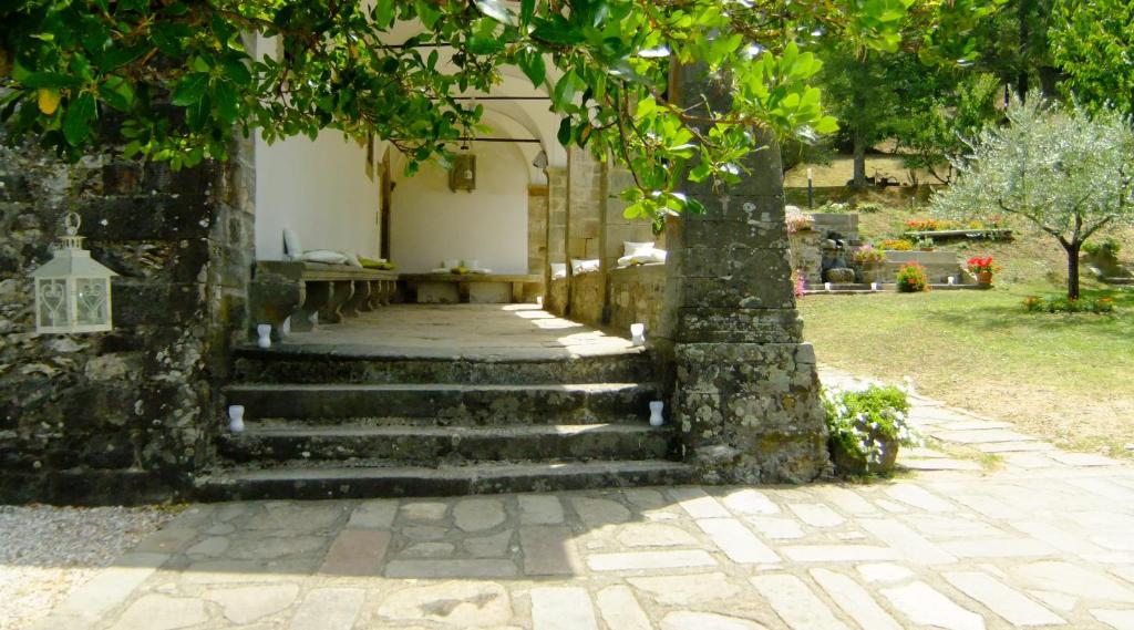 un conjunto de escaleras que conducen a una casa con un árbol en Convento del Carmine 4, en Fivizzano