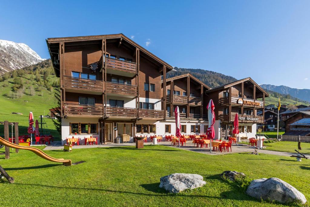 ein großes Gebäude mit einem Spielplatz davor in der Unterkunft Hotel Blinnenhorn in Reckingen - Gluringen