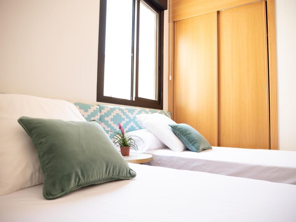 Łóżko lub łóżka w pokoju w obiekcie Stylish Apartment in the heart of Málaga with Pool