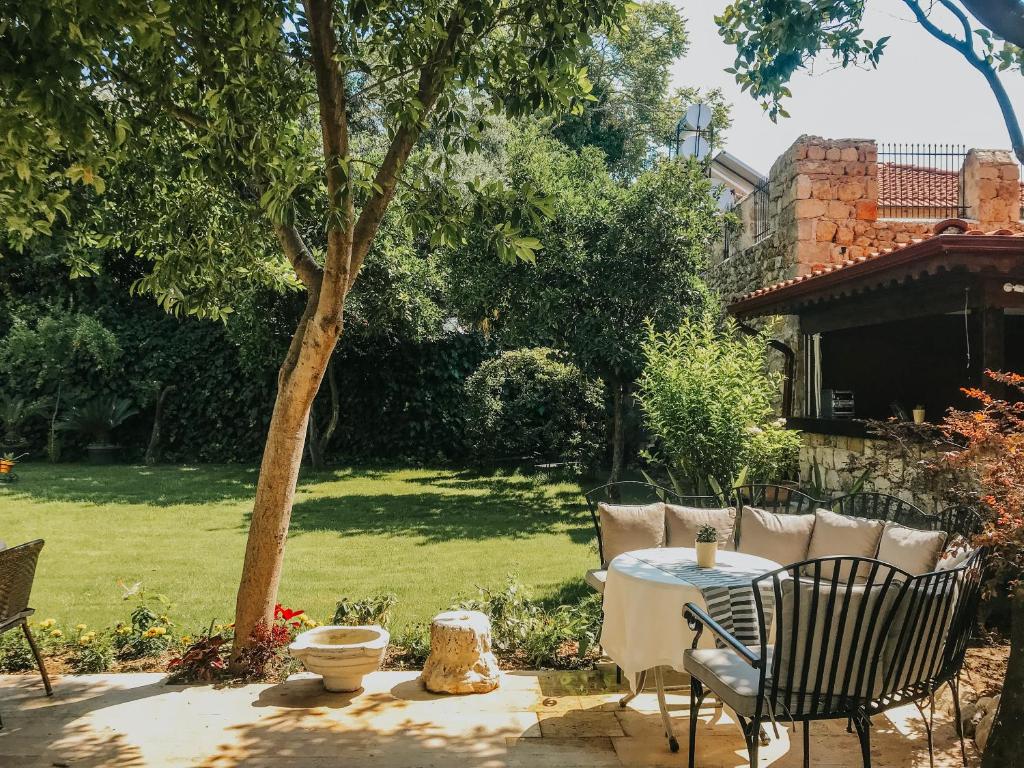 a patio with a table and chairs in a yard at The Ninova in Antalya