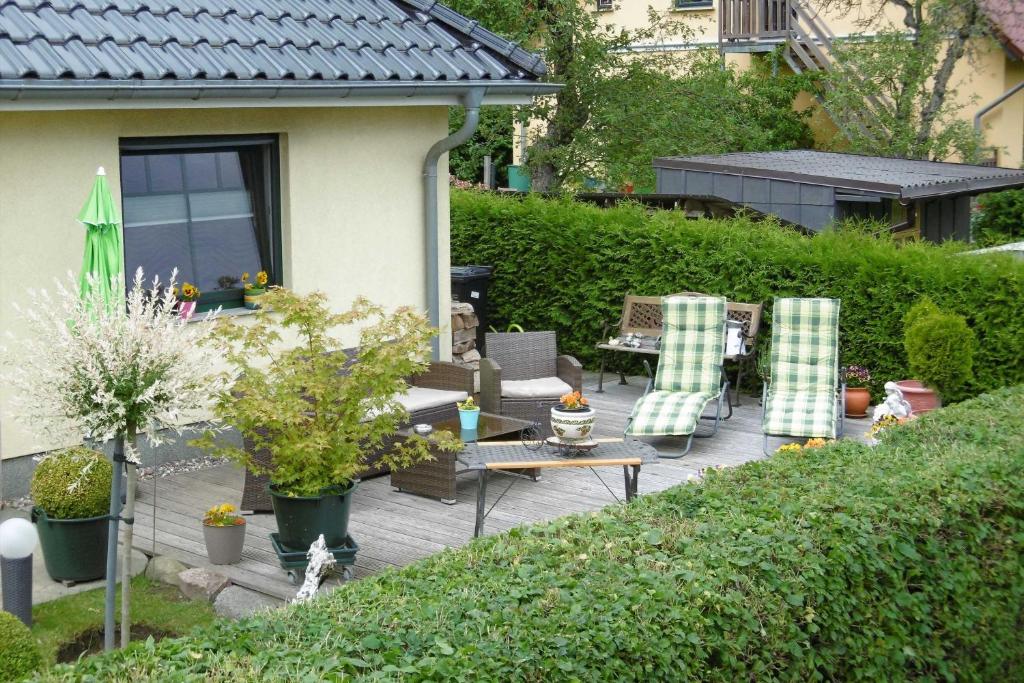 une arrière-cour avec une terrasse munie de chaises et d'une table dans l'établissement Ruegen_Fewo 62, à Putbus