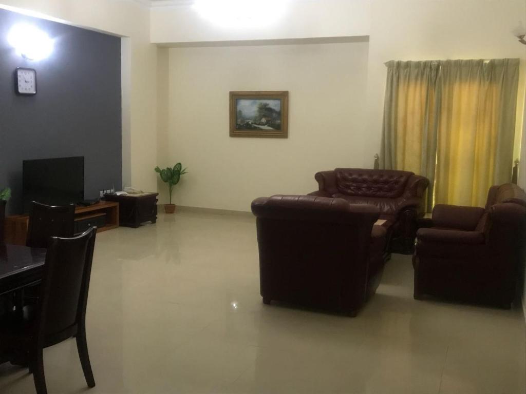 a living room with chairs and a couch and a tv at AL Sahab Tower in Manama