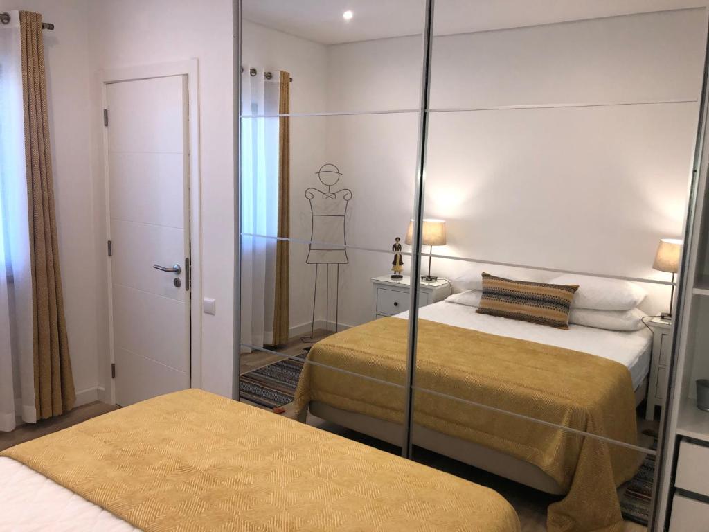 ヴィラモウラにあるApartamento 24 SOLのベッド2台と鏡が備わるホテルルームです。