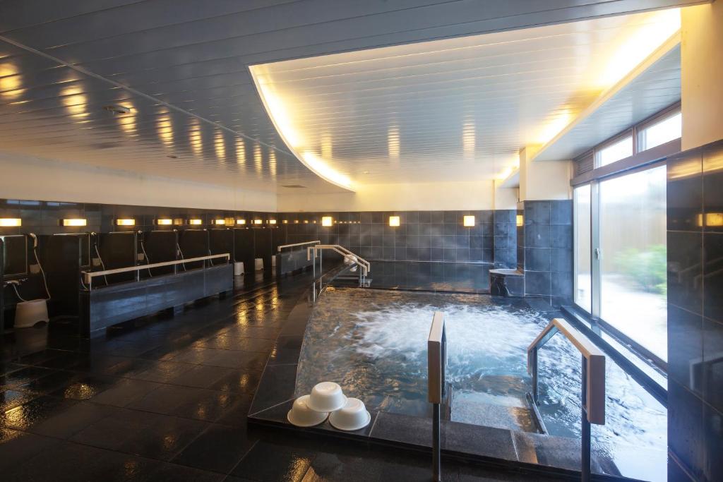 a bathroom with a bath tub with water at Hotel Izukyu in Shimoda