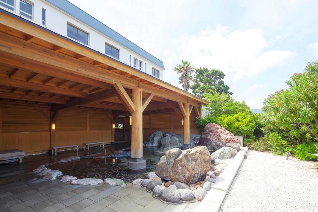 a large house with a covered patio with a fire pit at Hotel Izukyu in Shimoda