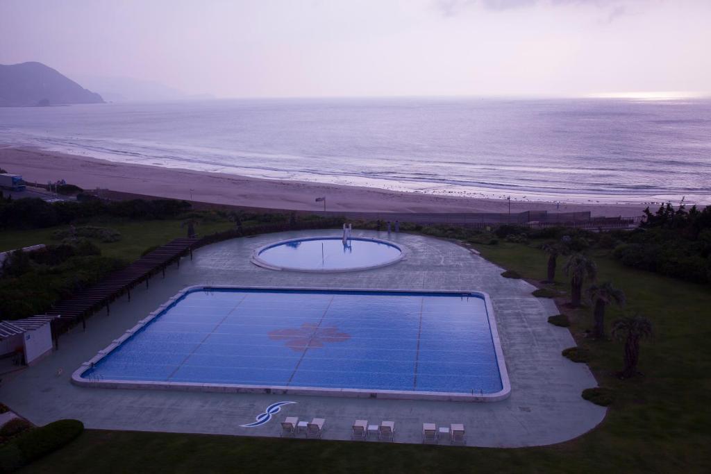 an overhead view of a swimming pool next to the beach at Hotel Izukyu in Shimoda