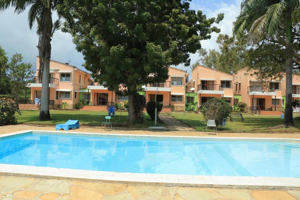a large swimming pool in front of some apartments at Makwetu Villas in Mombasa
