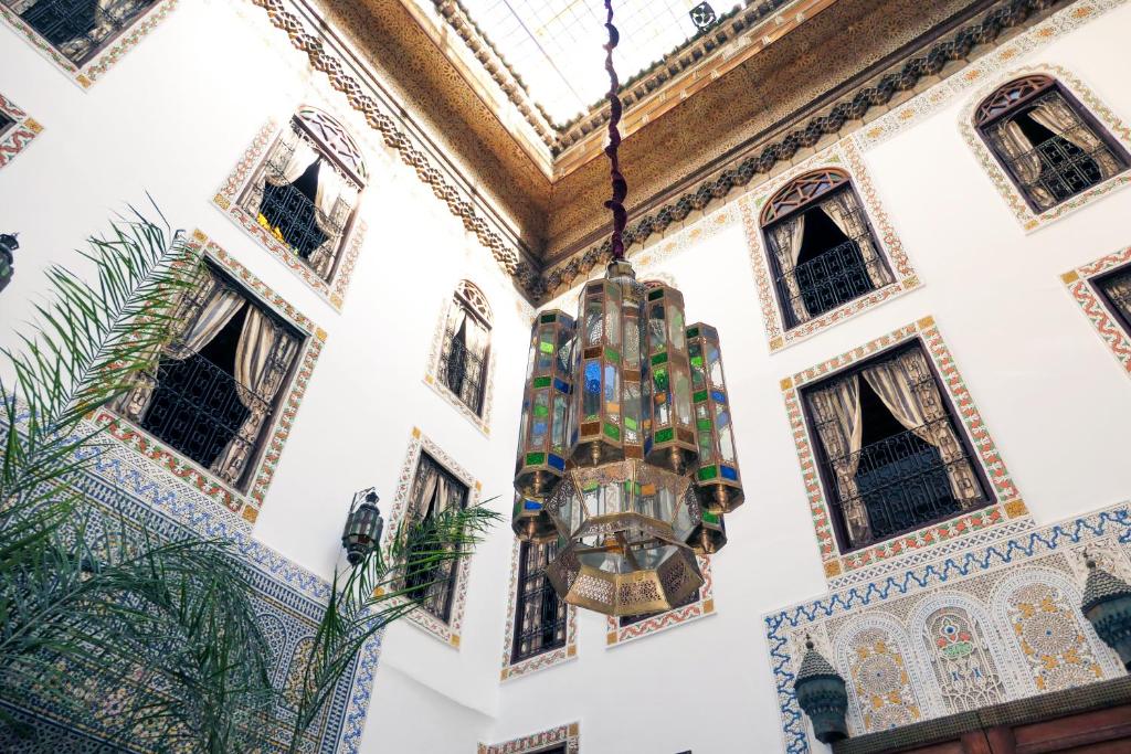 un lustre suspendu au plafond d'un bâtiment avec fenêtres dans l'établissement Riad Le Patio De Fes, à Fès