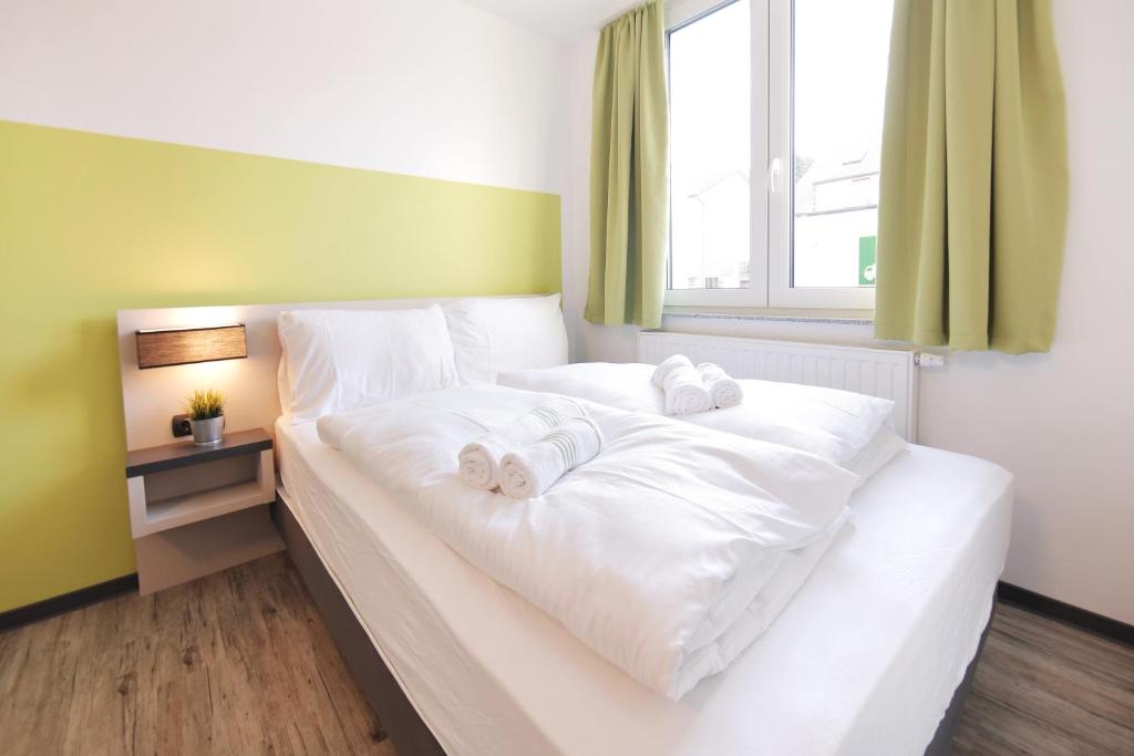 a bedroom with a white bed with towels on it at bestprice Hotel Eschweiler in Eschweiler