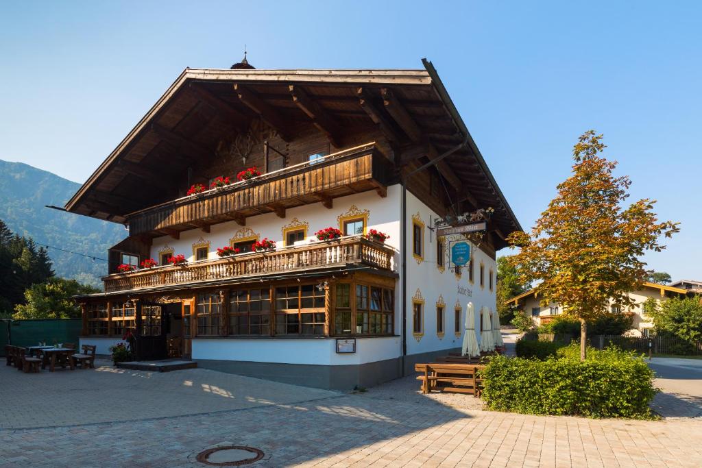 a building with a balcony with flowers on it at Rait´ner Wirt in Schleching