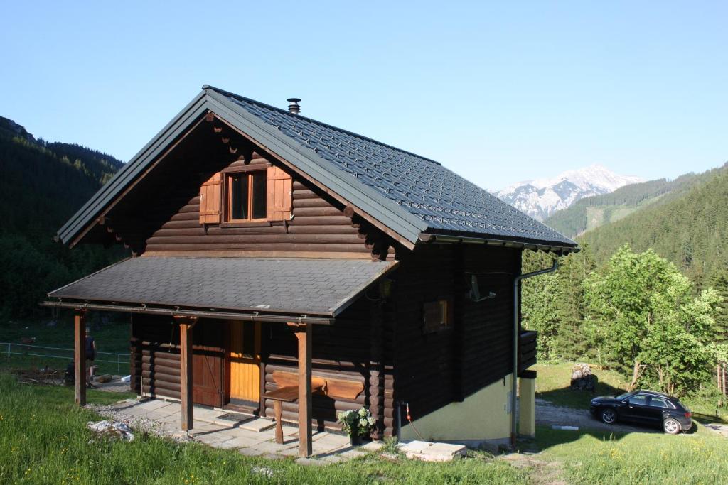 ein Blockhaus mit einem davor geparkt in der Unterkunft Blockhütte Radmer in Radmer an der Hasel