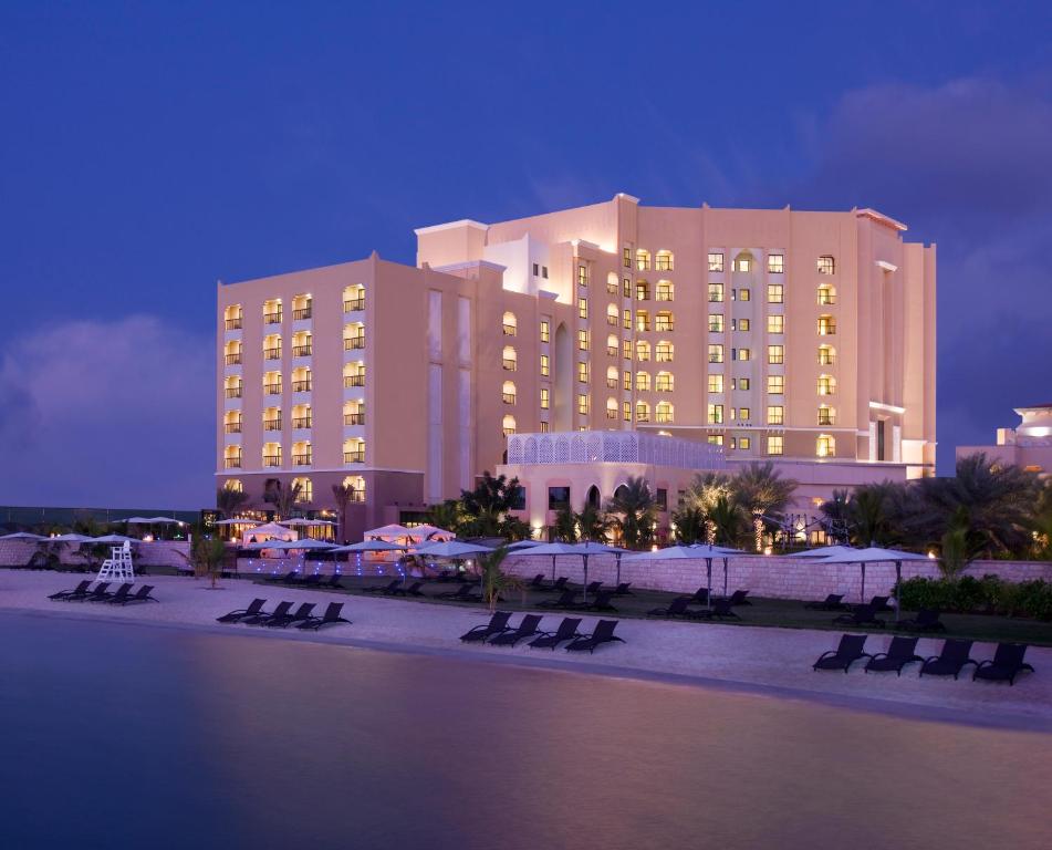 a large building with chairs in front of it at night at Traders Hotel, Abu Dhabi in Abu Dhabi