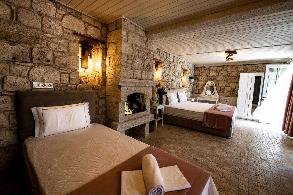 a bedroom with two beds and a fireplace at Çona Butik Otel in Alacati