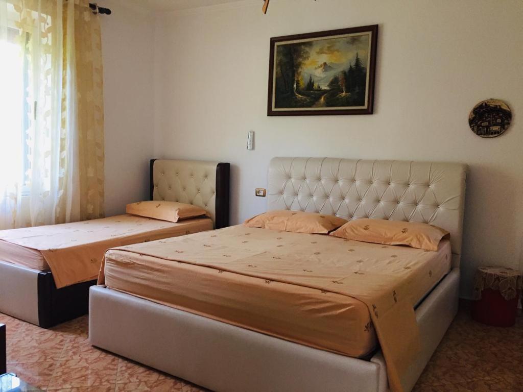 ein Schlafzimmer mit 2 Betten und einem Wandgemälde in der Unterkunft Jemin Apartment in Berat