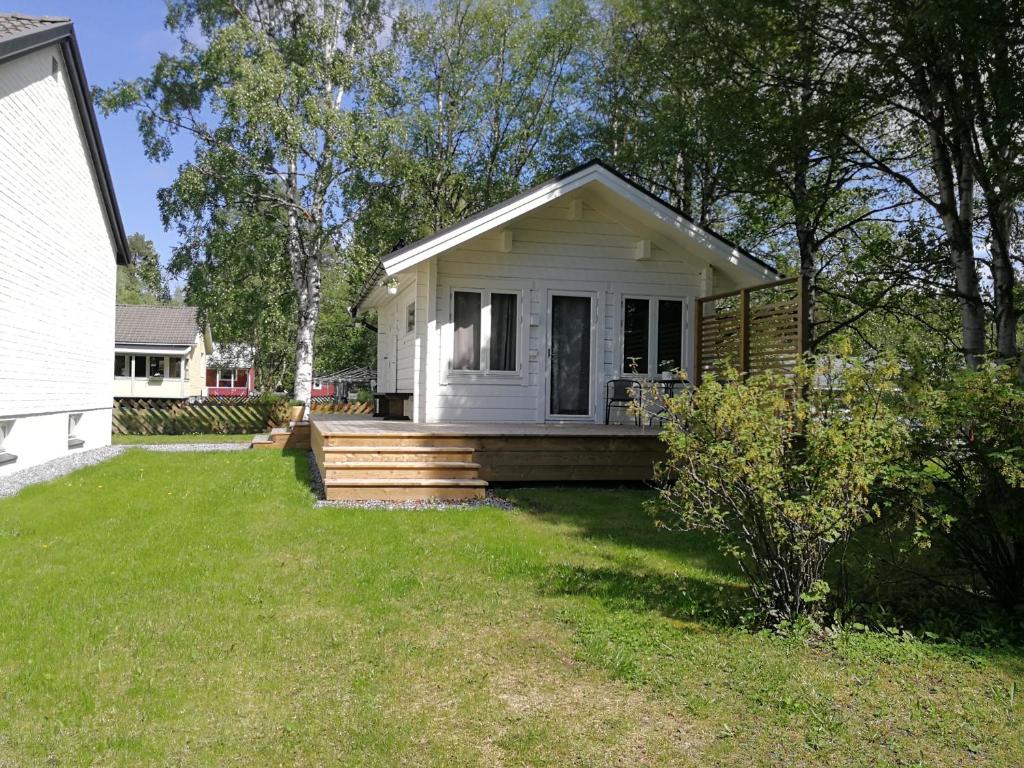 a small white house with a porch and a yard at 25 kvadrat 25 minuter från Åre in Järpen
