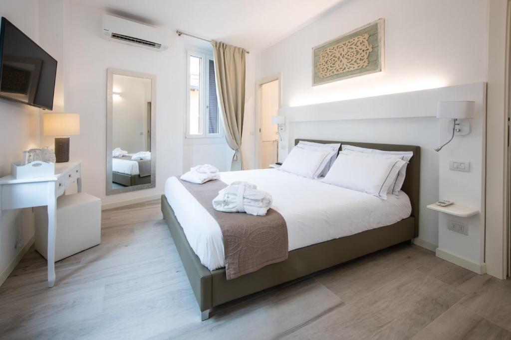 sypialnia z dużym łóżkiem i lustrem w obiekcie Residenza Elisa w mieście Desenzano del Garda