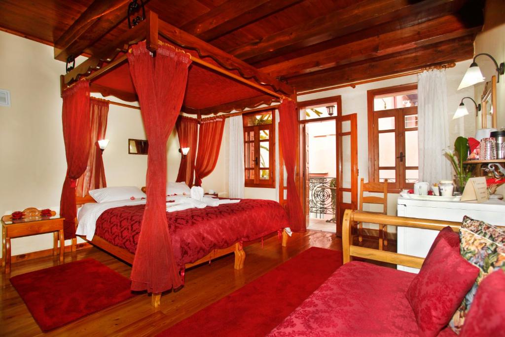 - une chambre avec un lit à baldaquin et des rideaux rouges dans l'établissement Palazzo di Pietro, à La Canée
