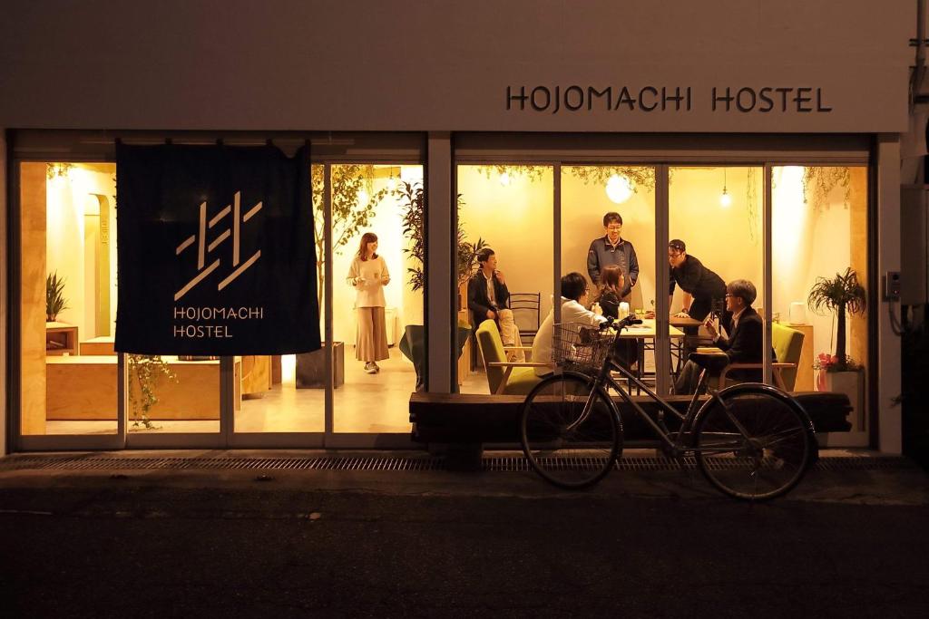 a group of people standing in front of a store at HOJO MACHI HOSTEL in Kasai