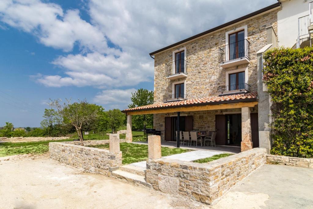 ein Steinhaus mit einer Terrasse davor in der Unterkunft Villa Luka in Brtonigla