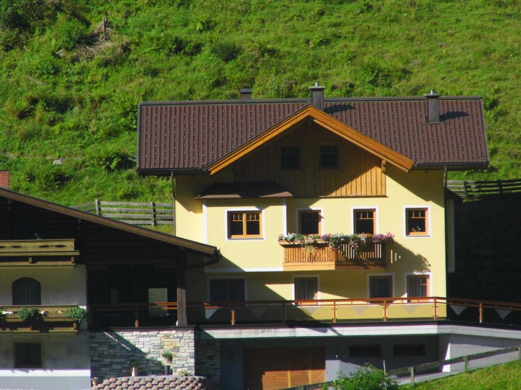 ein Haus mit einem Balkon mit Blumen darauf in der Unterkunft Ferienwohnung Viehhauser in Hüttschlag