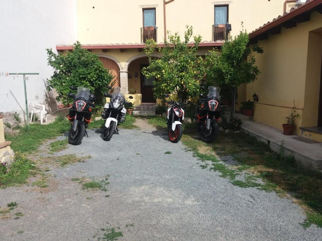 three motorcycles parked in front of a house at B&B Gli Archi in Sìnnai