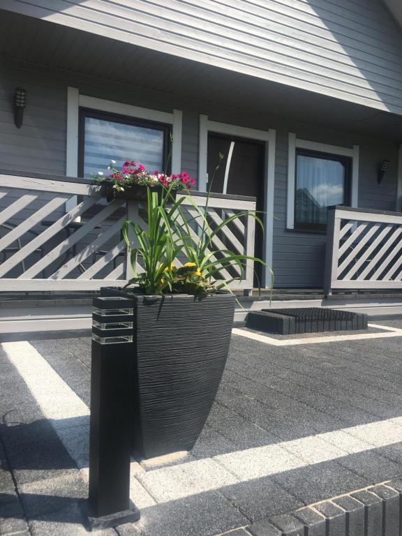 a house with a planter with flowers in it at Domki Letniskowe "TROPIK" in Dębki