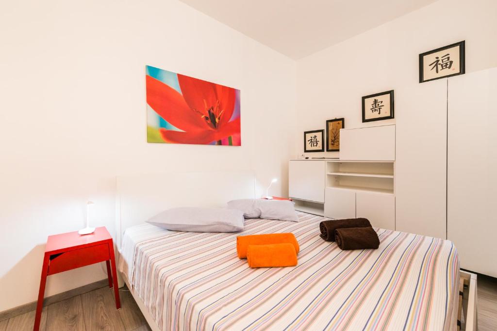 Habitación blanca con cama y mesa roja en Geco's Apartment, en Elmas