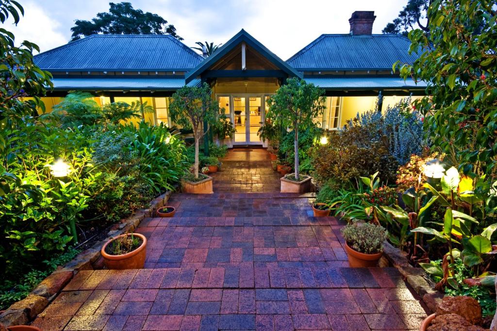 a house with a brick walkway with potted plants at Margaret River Guest House in Margaret River Town