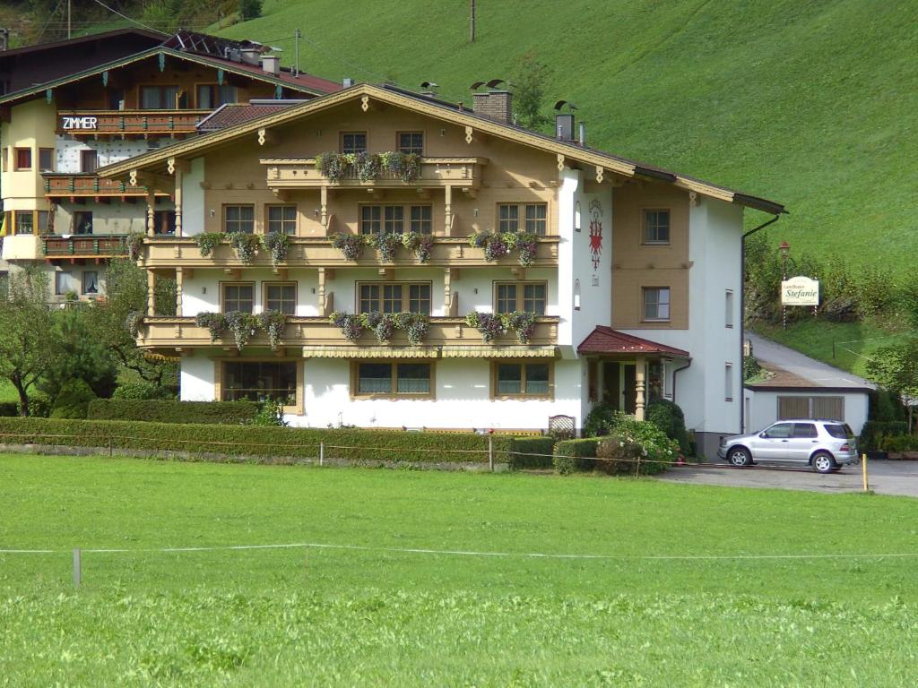 ein großes Haus mit einem grünen Feld davor in der Unterkunft Landhaus Tirol in Zellberg