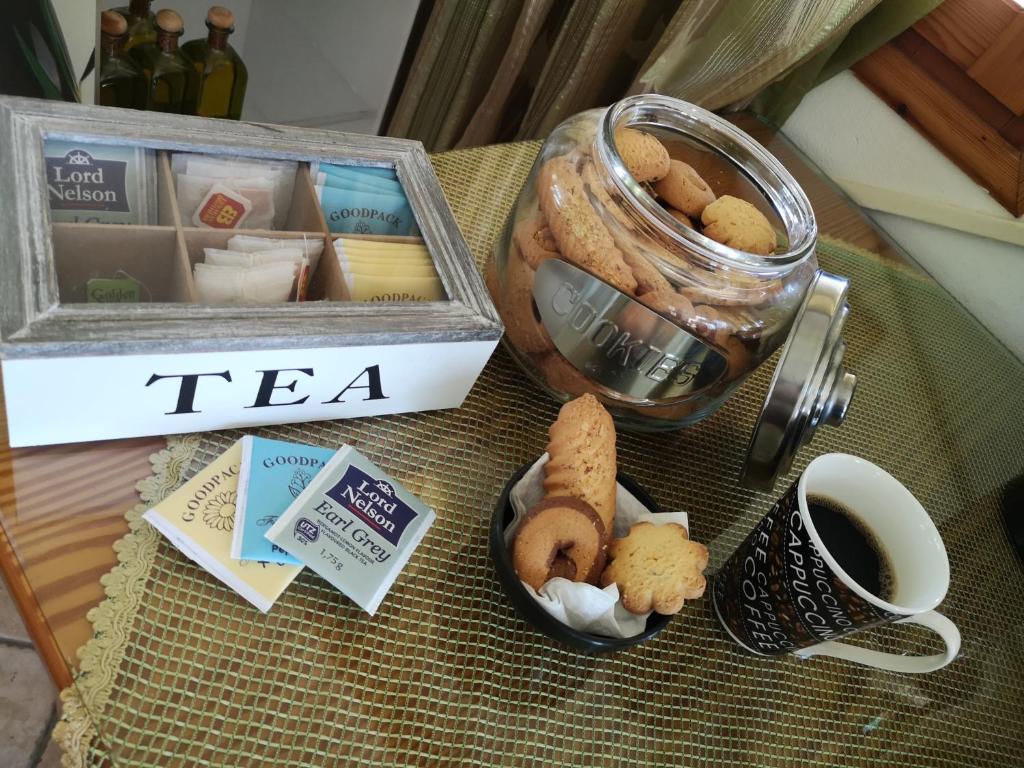 a table with a jar of tea and cookies and a cup of coffee at Dimitris Villa Hotel in Matala