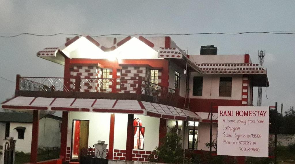 a large red and white house with a sign in front at Rani Homestay in Cherrapunji