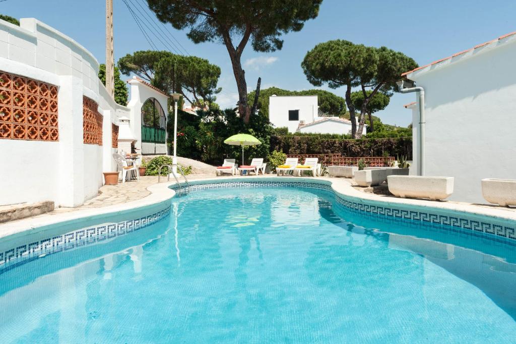 a swimming pool with blue water in a house at Catarina in L'Escala