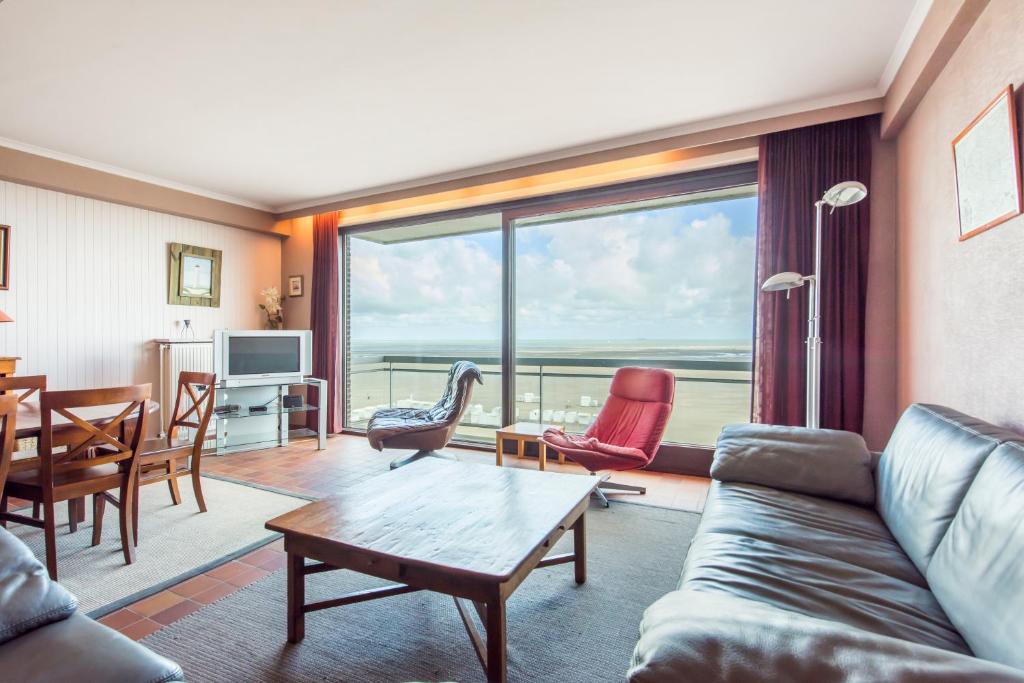 ein Wohnzimmer mit einem Sofa und einem Tisch in der Unterkunft Ascot 5de in Zeebrugge