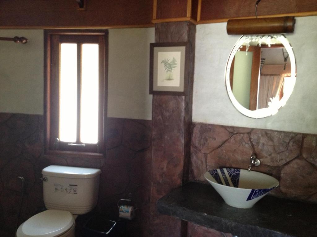 a bathroom with a toilet and a mirror at Malibu Beach Bungalows in Chaloklum