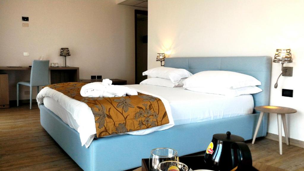 a bedroom with a blue bed with white sheets and pillows at Fantinello Hotel in Caorle