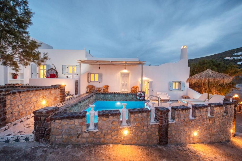 a villa with a swimming pool at night at Starlight Luxury Seaside Villa & Suites in Imerovigli