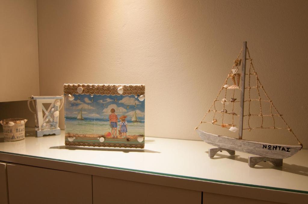a shelf with a toy sailboat and a picture on it at Nautilus Nontas Hotel in Megalochori