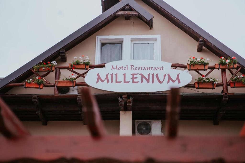 a sign on the side of a building with a window at Hotel-Restaurant Milenium in Salonta