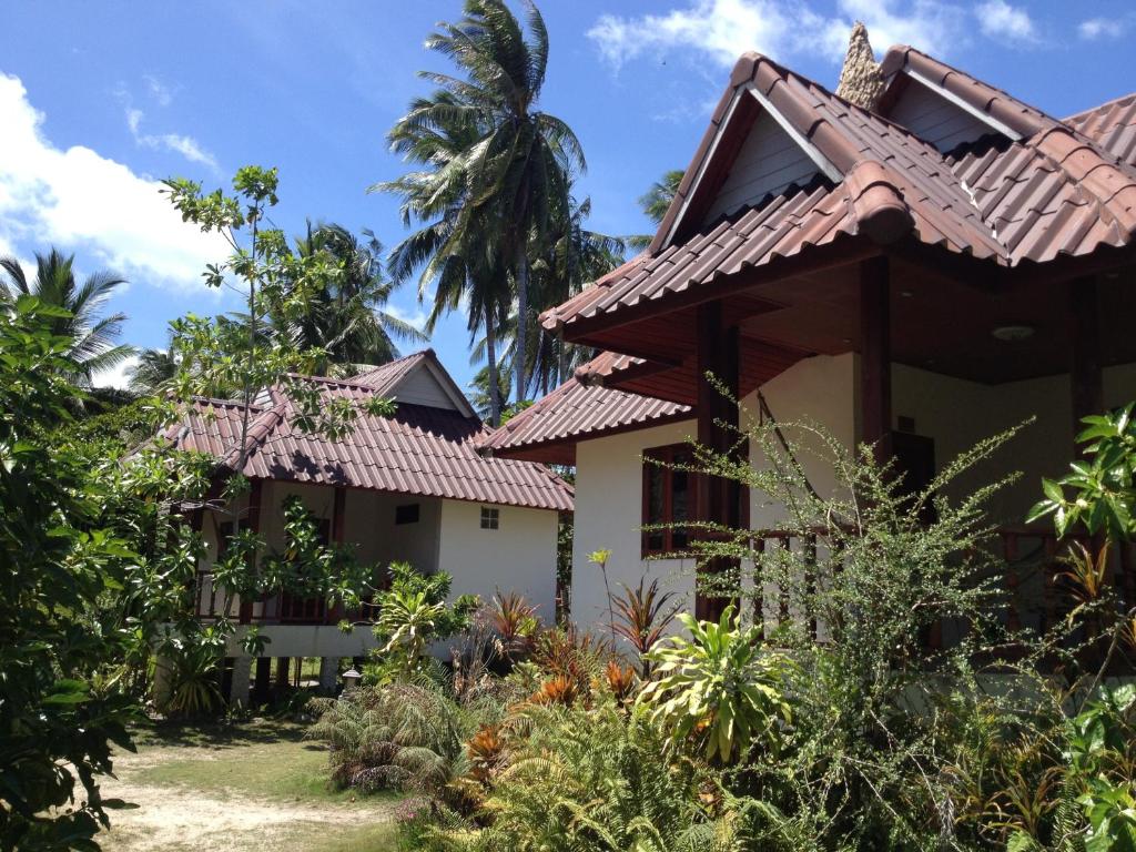 a house with a palm tree in the background at Malibu Beach Bungalows in Chaloklum